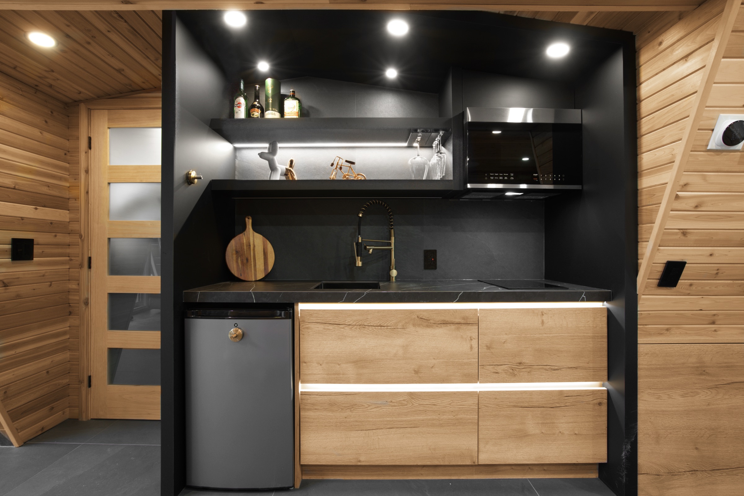 Black upper cabinets and countertop above wood-grain drawers