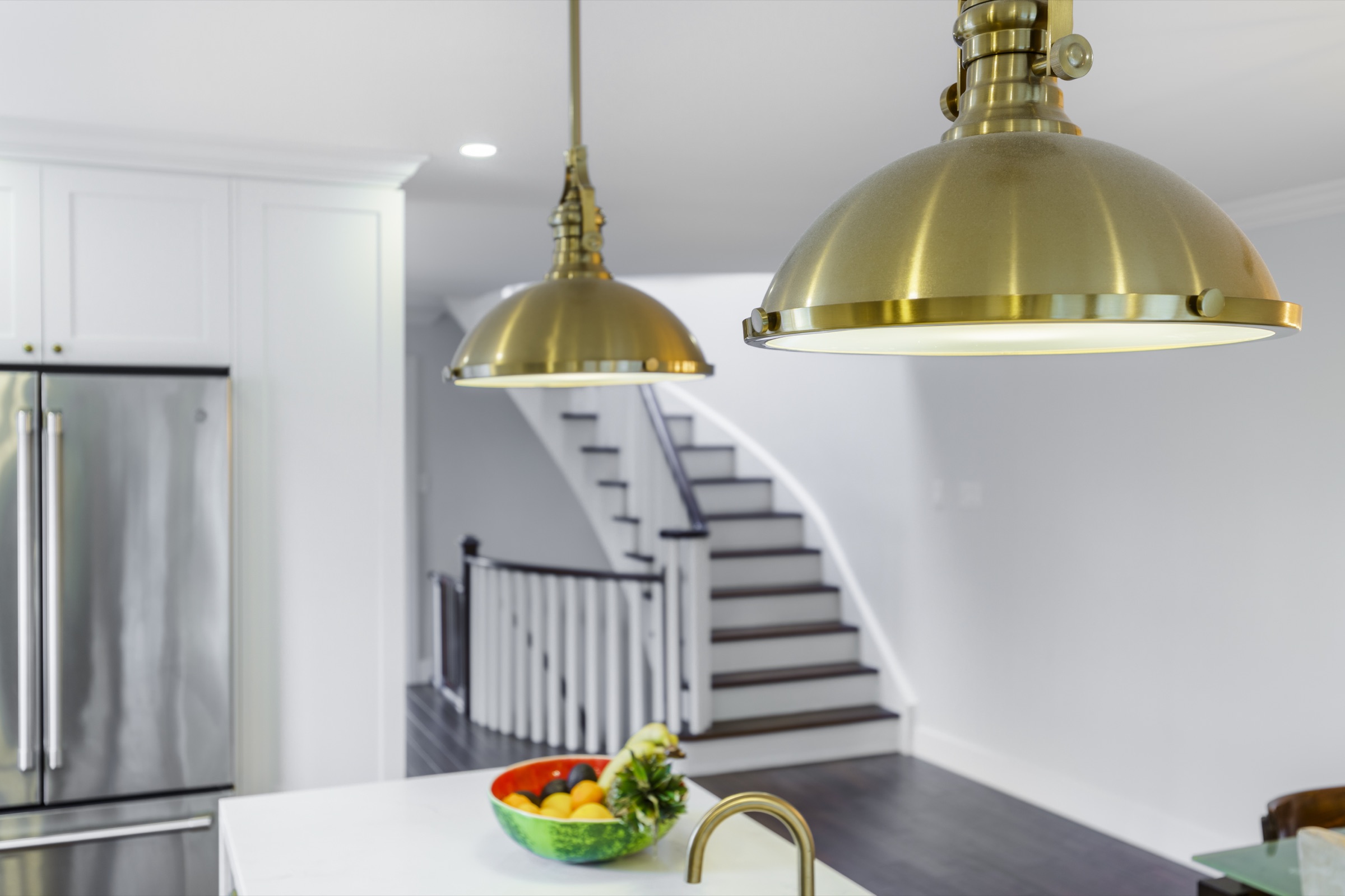 Gold-coloured pendant lights above a kitchen island