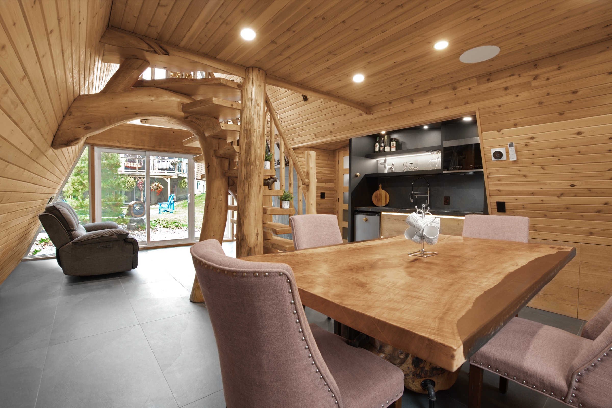 Dark kitchen and dining table within a timber-lined room