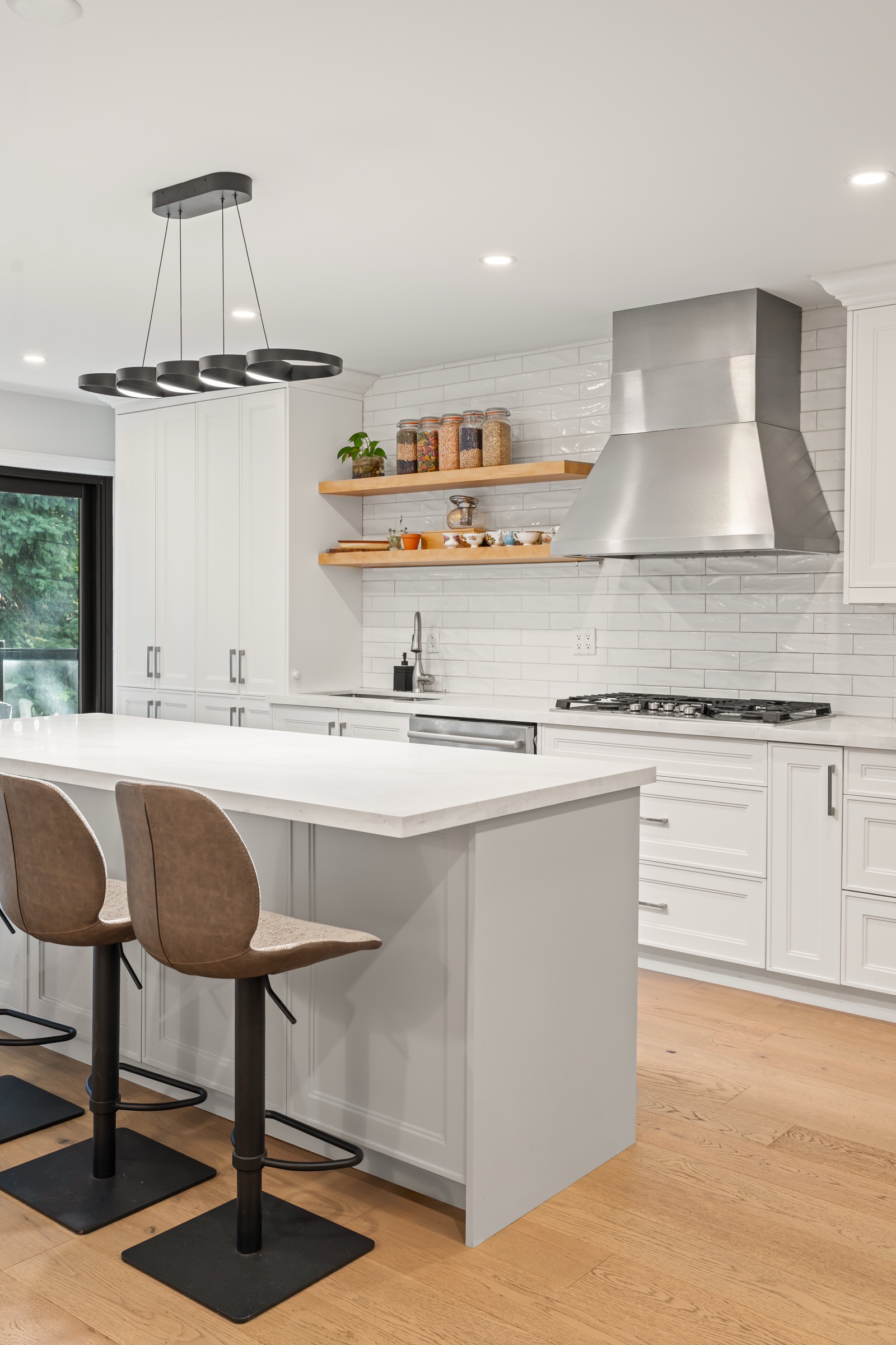 White kitchen island with stools and open shelves
